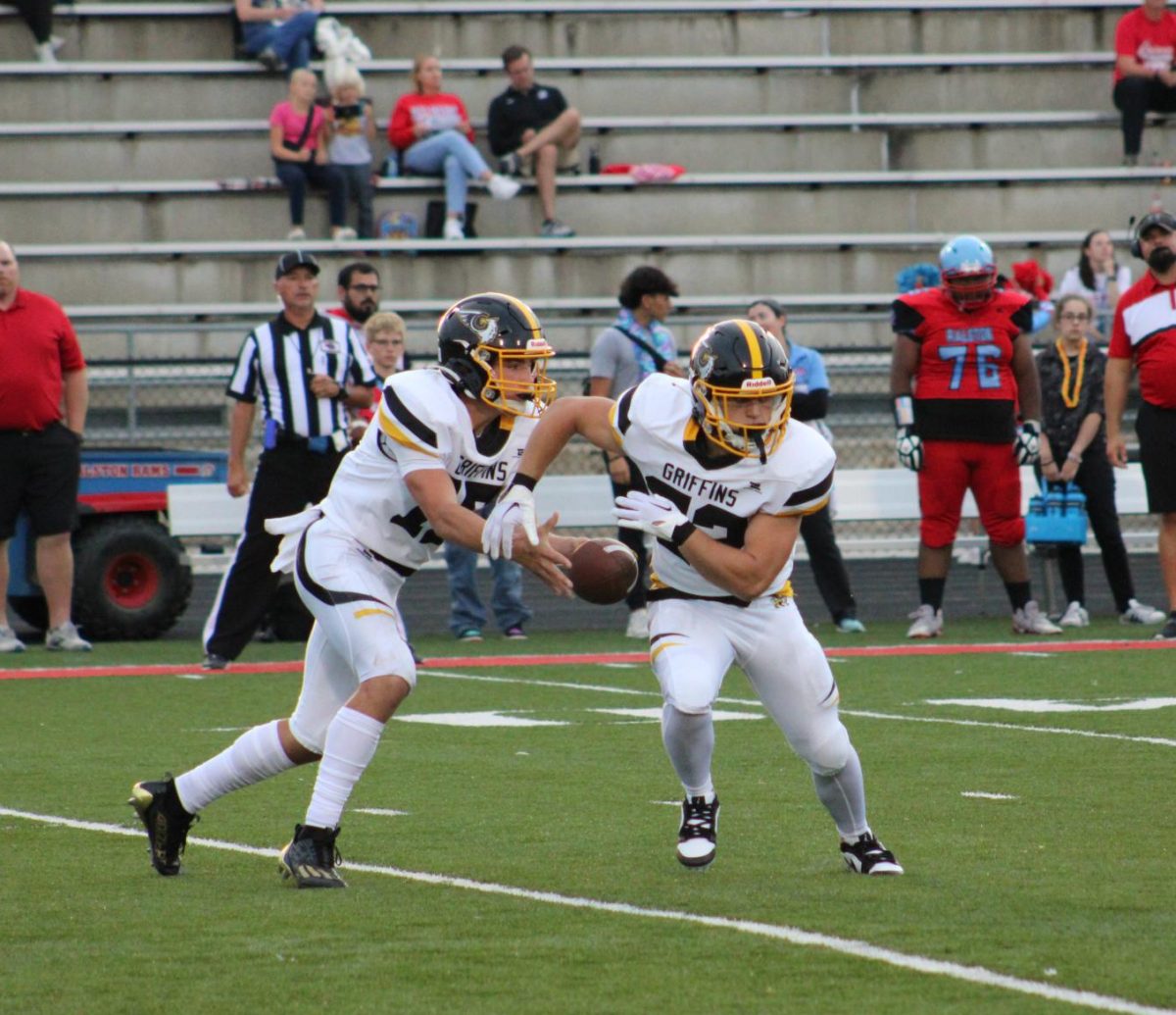 On the 25 yard line, Chase Grow (9) hands the ball off to Mason Gunn (11) in the 2nd quarter on 1st down.