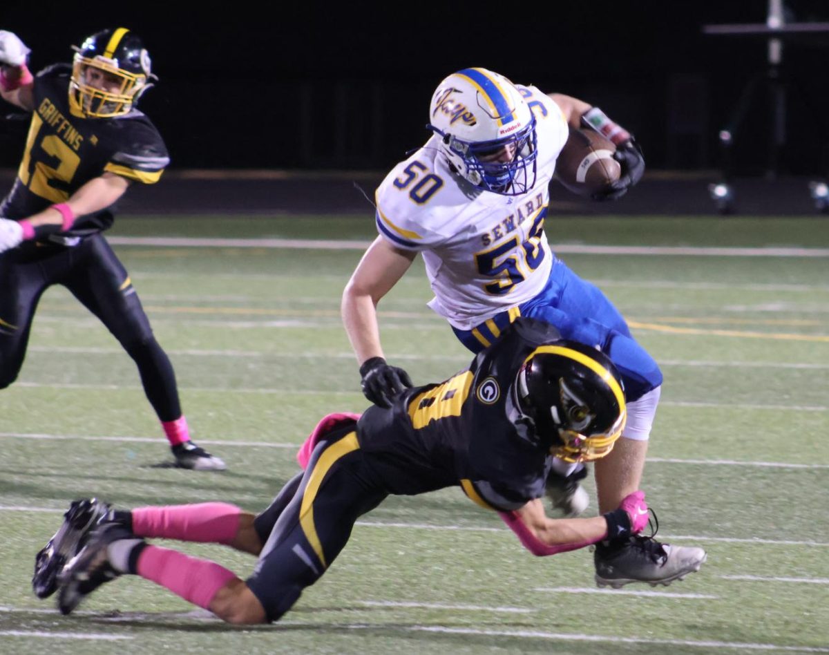Running toward the offensive player, Logan Kracht (10) dives for a tackle in the third quarter.