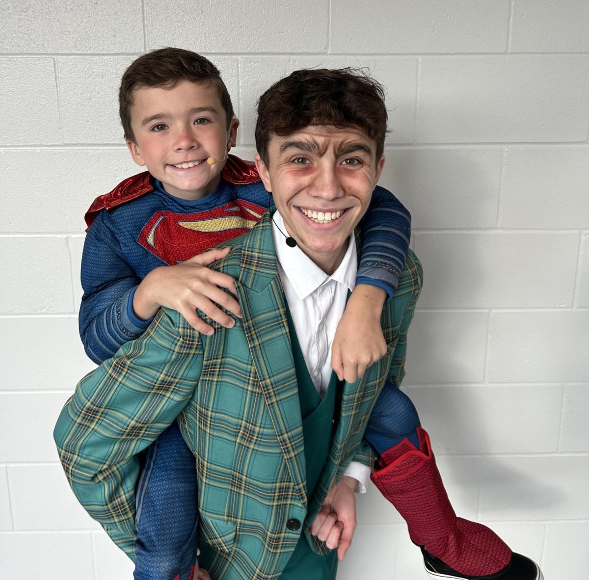 Giving his brother, fourth grader, Landen Knott, a piggy back ride, junior Colton Knott poses for a photo before their dress rehearsal performance of Matilda the Musical Thursday morning for Gretna Public Schools elementary school students. Colton Knott played the lead male role, Mr. Woormwood, while his brother shared the stage with him playing Nigel, who is a kid in Matildas class. 
