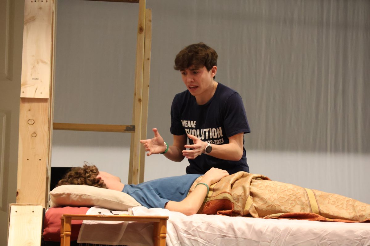 Reacting to not finding a pulse, Colton Knott (11) who plays Max in Lend Me a Tenor, acts panicked and presumes Tito Mirelli, played by Andrew Jones (11), is dead during practice on Nov. 7. Making use of the little set equipment they had, the bed Jones uses for the show is a hand-me-down from Matilda the Musical, which was performed in October.