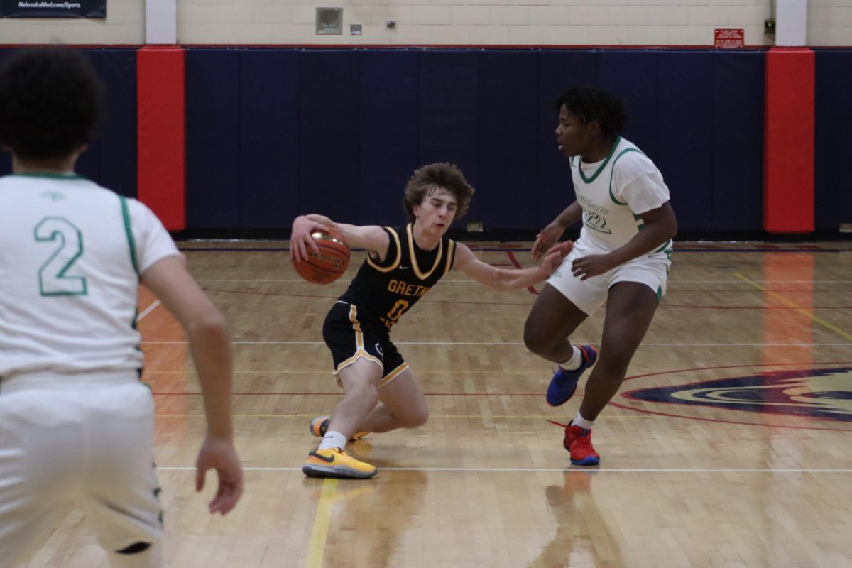 Dribbling up the court, junior guard Talan Hovie crosses over to lose his defender.