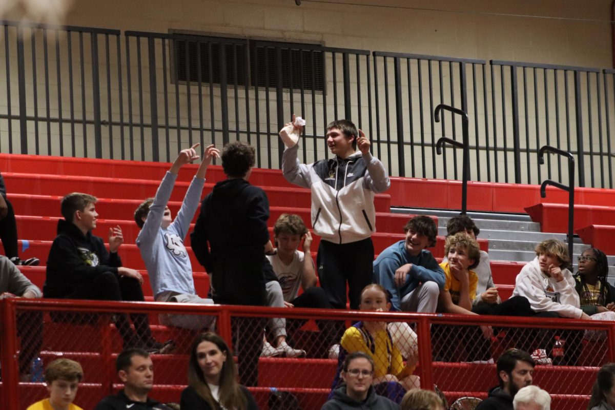Cheering on his brother during the timeout, freshmen Beck Hovie does the Jump Around dance.