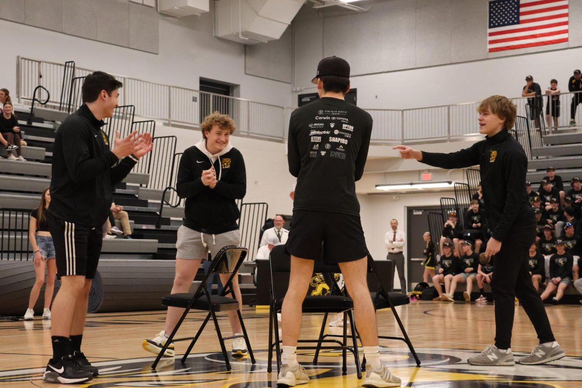 Celebrating not getting themselves eliminated, sophomore Caden Annis and juniors Grayson Fisher, Tyler Cox and Luke Silliman prepare for the second to last round of the musical chairs class competition.
