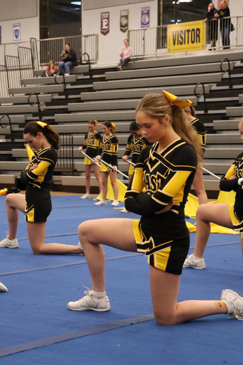 Preparing for their performance, sophomore Hallie Odermatt and the rest of the varsity cheer team wait for the music to start.