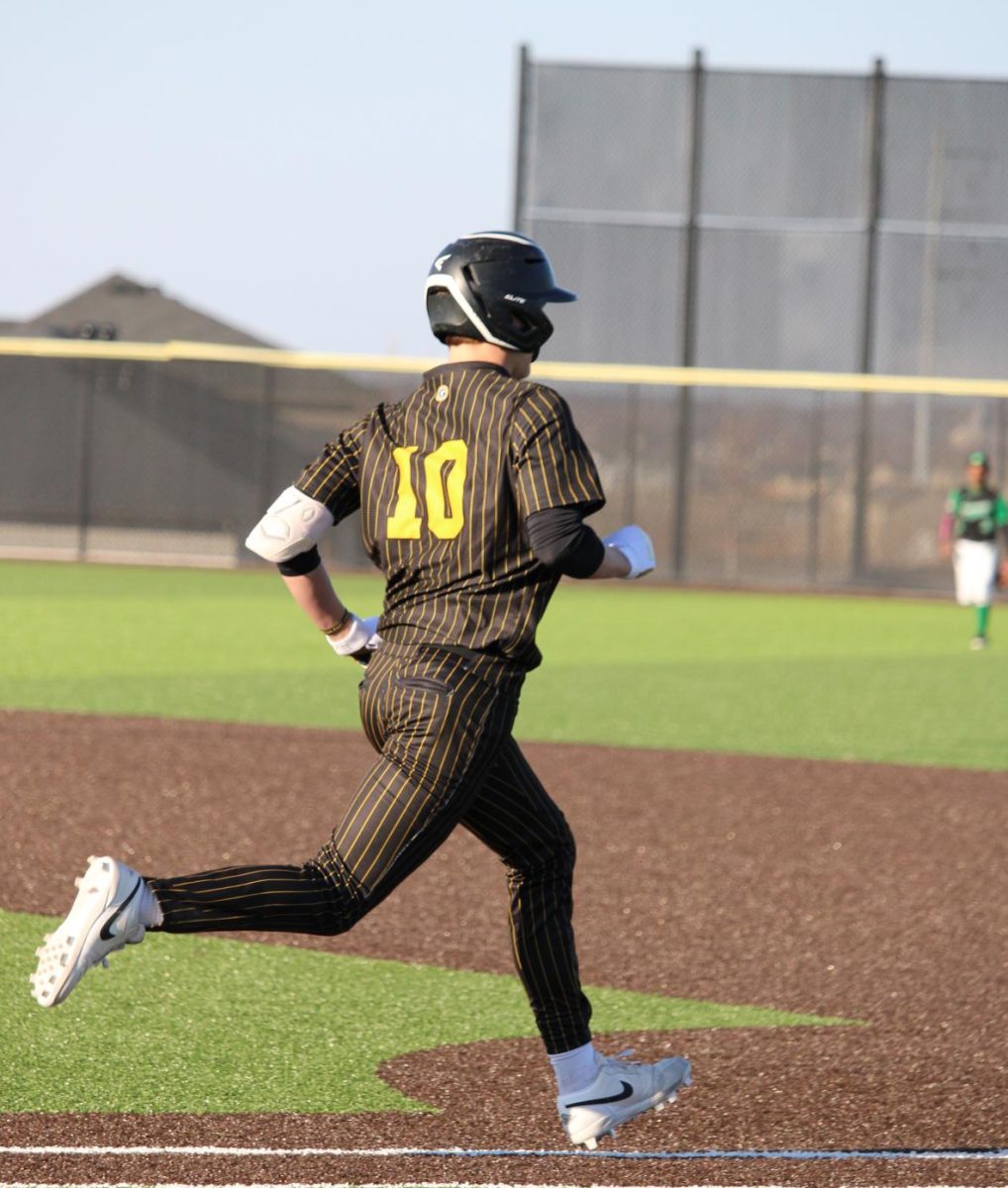 In their season opener on March 15 against Omaha Benson, sophomore Carson Herrmann runs to first. Herrmann had two runs and four runs batted in, contributing to the Griffins first shut-out, defeating the Bunnies 30-0.