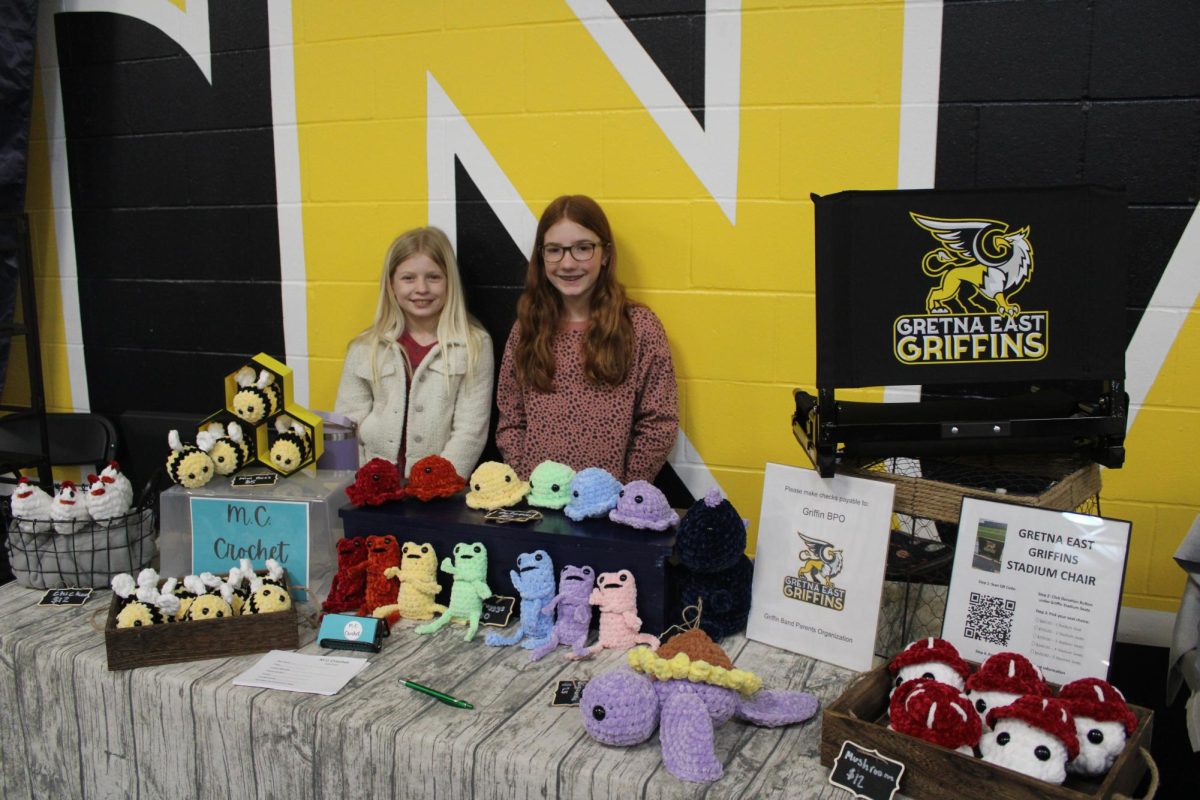 Helping fundraise for the Griffin band, Cambria Kopetzky (6) and (find name) crochet stuffed frogs, bees and mushrooms at their booth for M.C. Crochet.