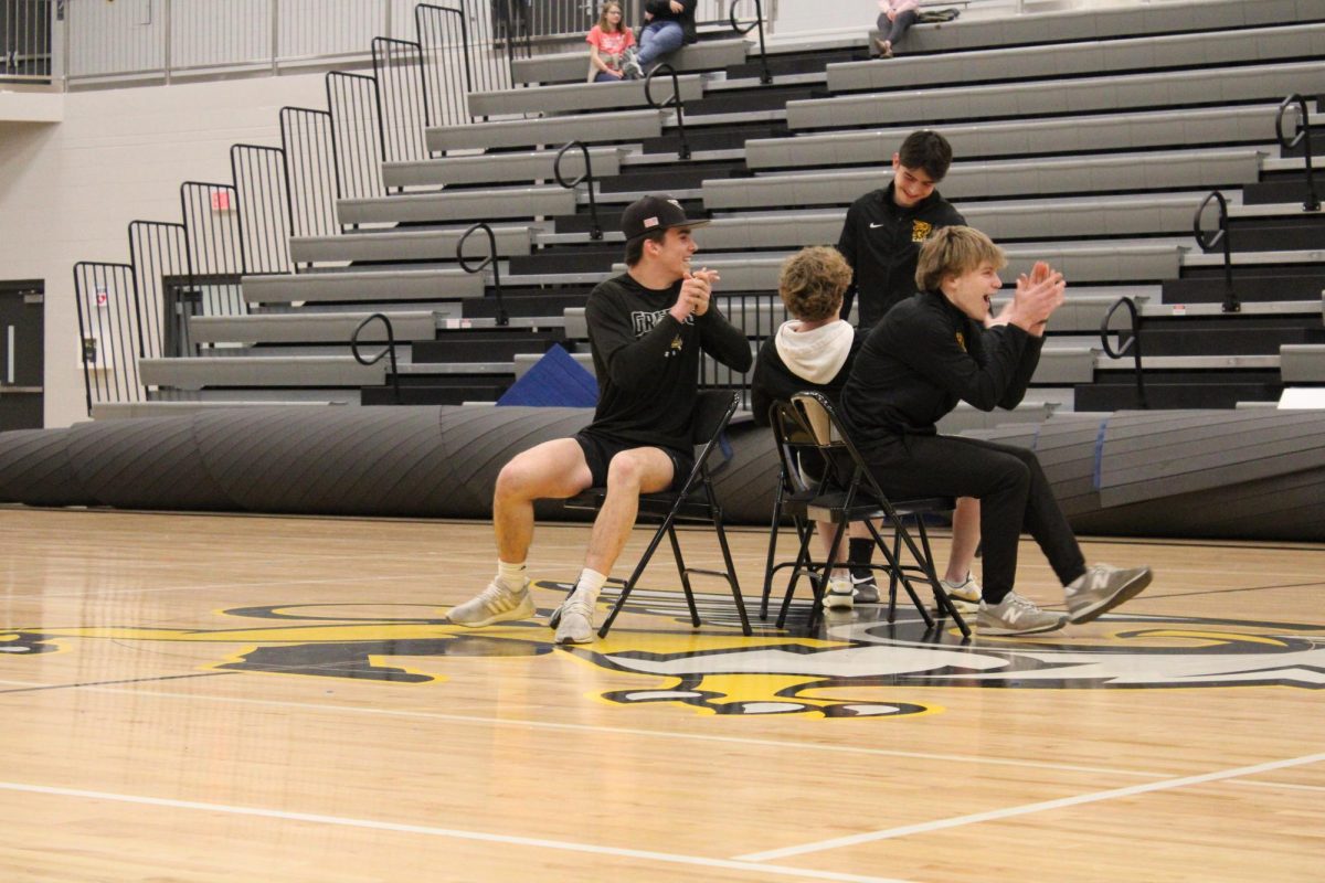 Being a good sport, sophomore Caden Annis smiles after his loss while juniors Tyler Cox and Luke Silliman celebrate. Three juniors made it to the final round of the class competition musical chairs last night.