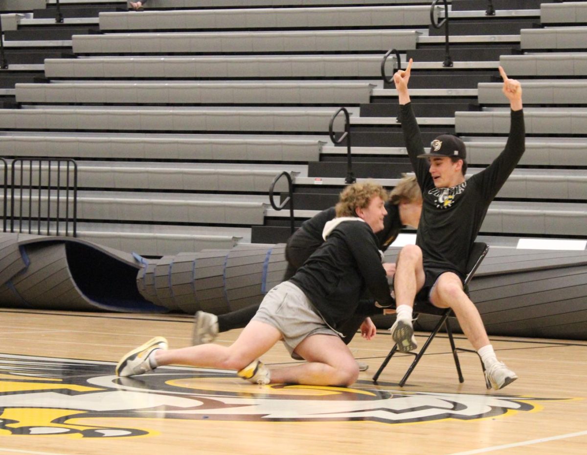Celebrating his victory, junior Tyler Cox raises his hands after winning the final round of the class competition musical chairs. This victory pushed the junior class to win the overall, year-round class competition.