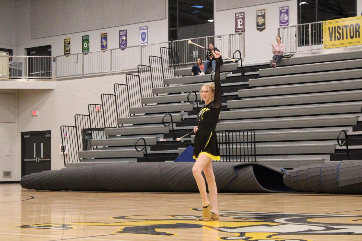 Holding her baton up high, freshman Ellisyn Barker poses during her twirling routine at the pep rally. Barker also performed at the winter pep rally on Nov. 16. 