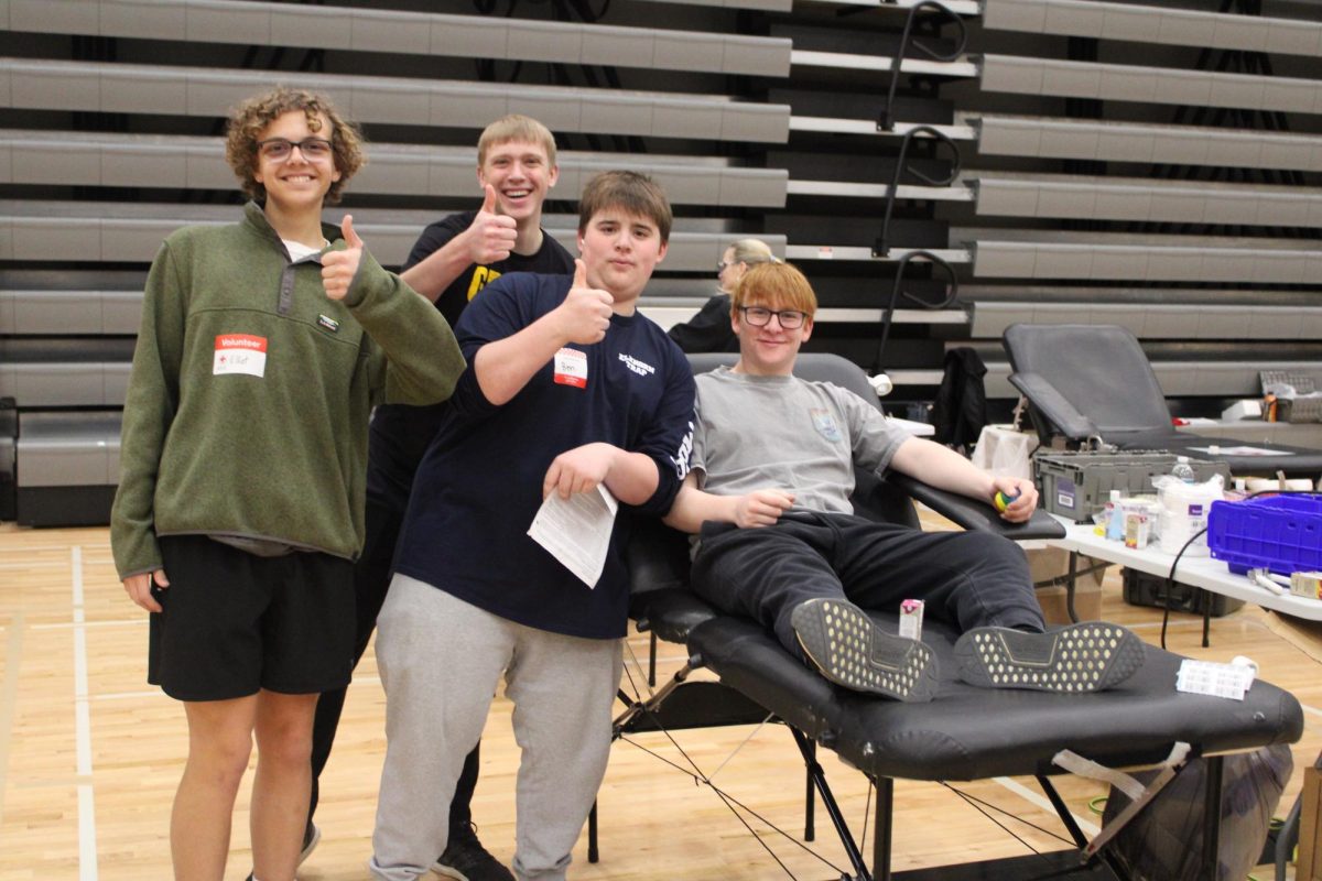 Supporting their friend and brother, juniors Calvin Zabloudil and Benjamin Morgan along with sophomore Elliot Reece give a thumbs up before junior Charles Morgans donation. 