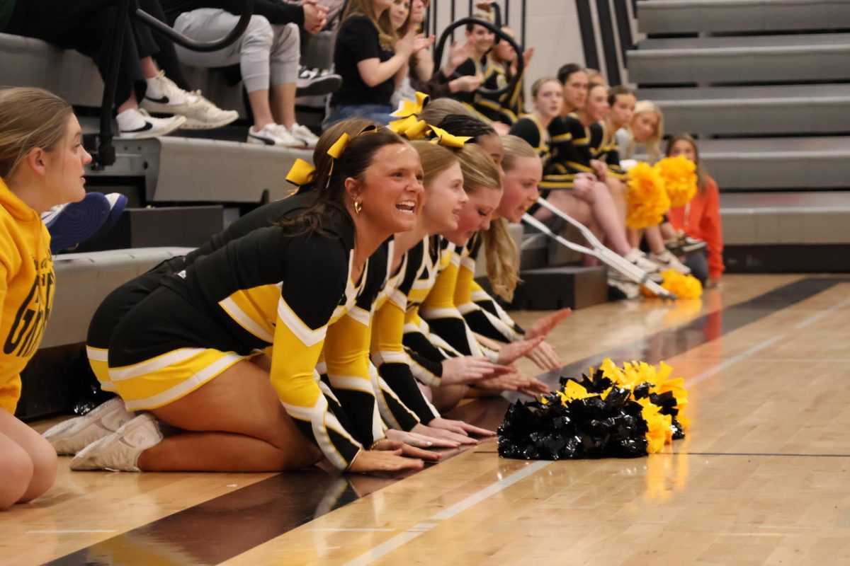 Making noise by hitting the floor, freshman Ella Gernetzke and the rest of the junior varsity cheer team supports the varisty cheer team during the spring pep rally.