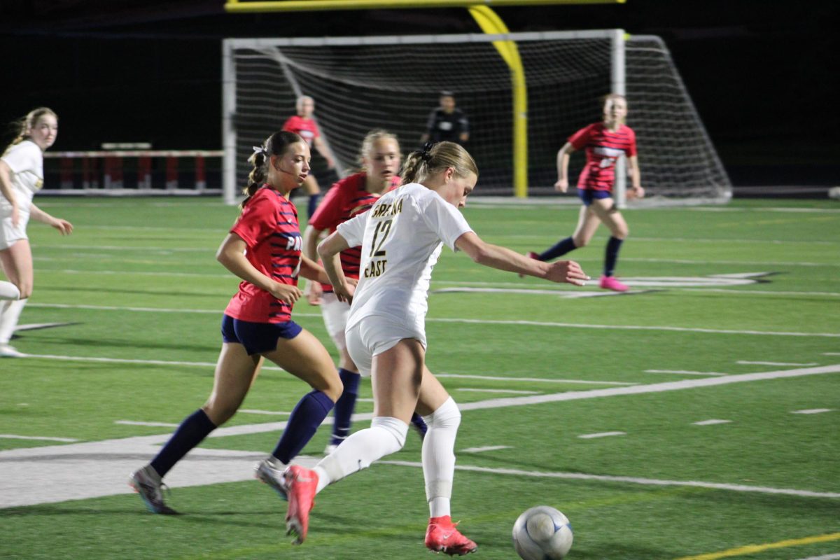 Dribbling the ball, junior Kendall Dobberstein makes her way down the field with two Millard South defenders closing in during game one of the Millard South Invite on April 16.