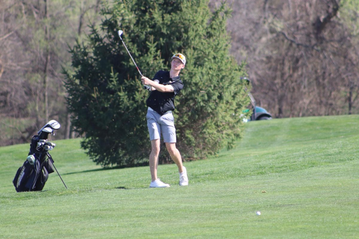 Chipping onto the green from 100 yards out, junior Cole Edwards watches the ball as it is in flight.