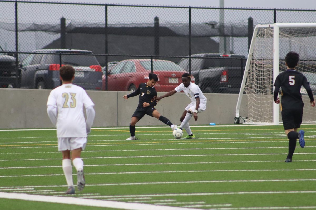 Stealing the ball from the attacking opponent, junior Timothy Thang prevents a goal early in the first half.
