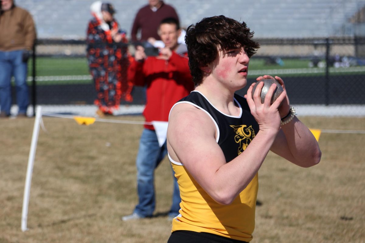 Preparing for his first throw, sophomore Connor Sams holds the shot put in his hands before attempting his first throw of the meet.