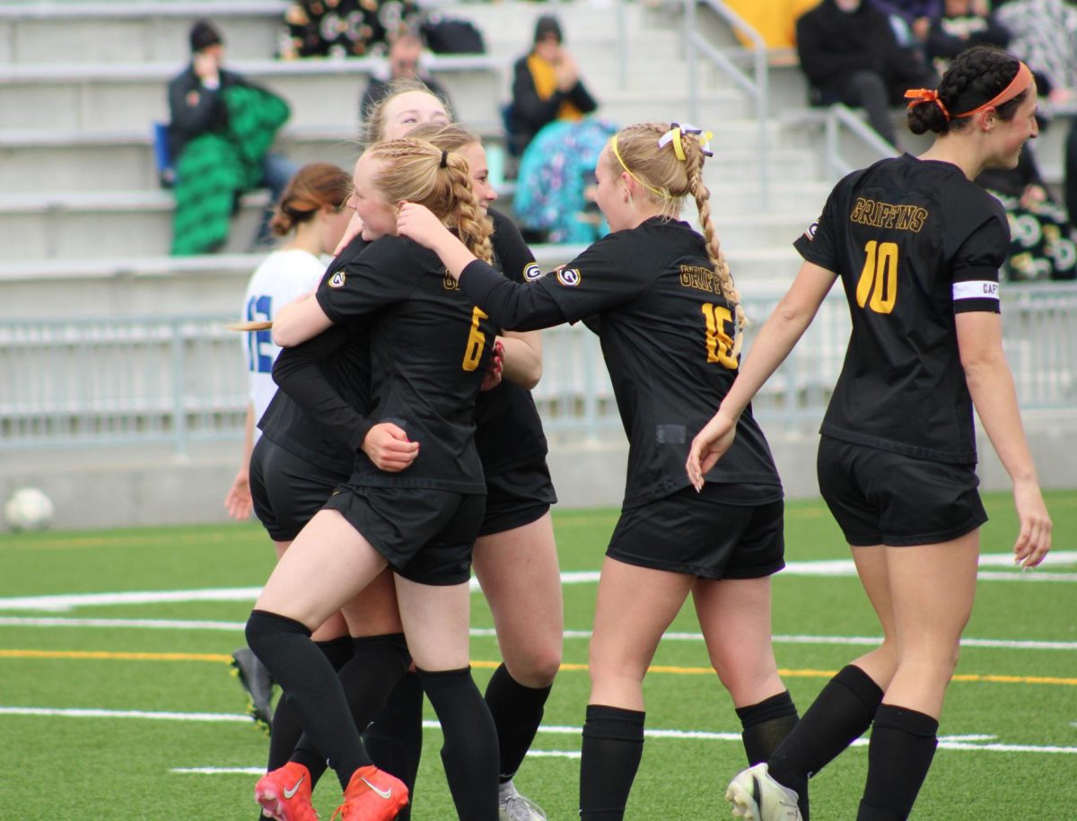 Surrounding their teammate, the Griffins hug and support junior Kendall Dobberstein after breaking the Class B record for most assists within a season. Dobberstein has 29 assists so far this season.