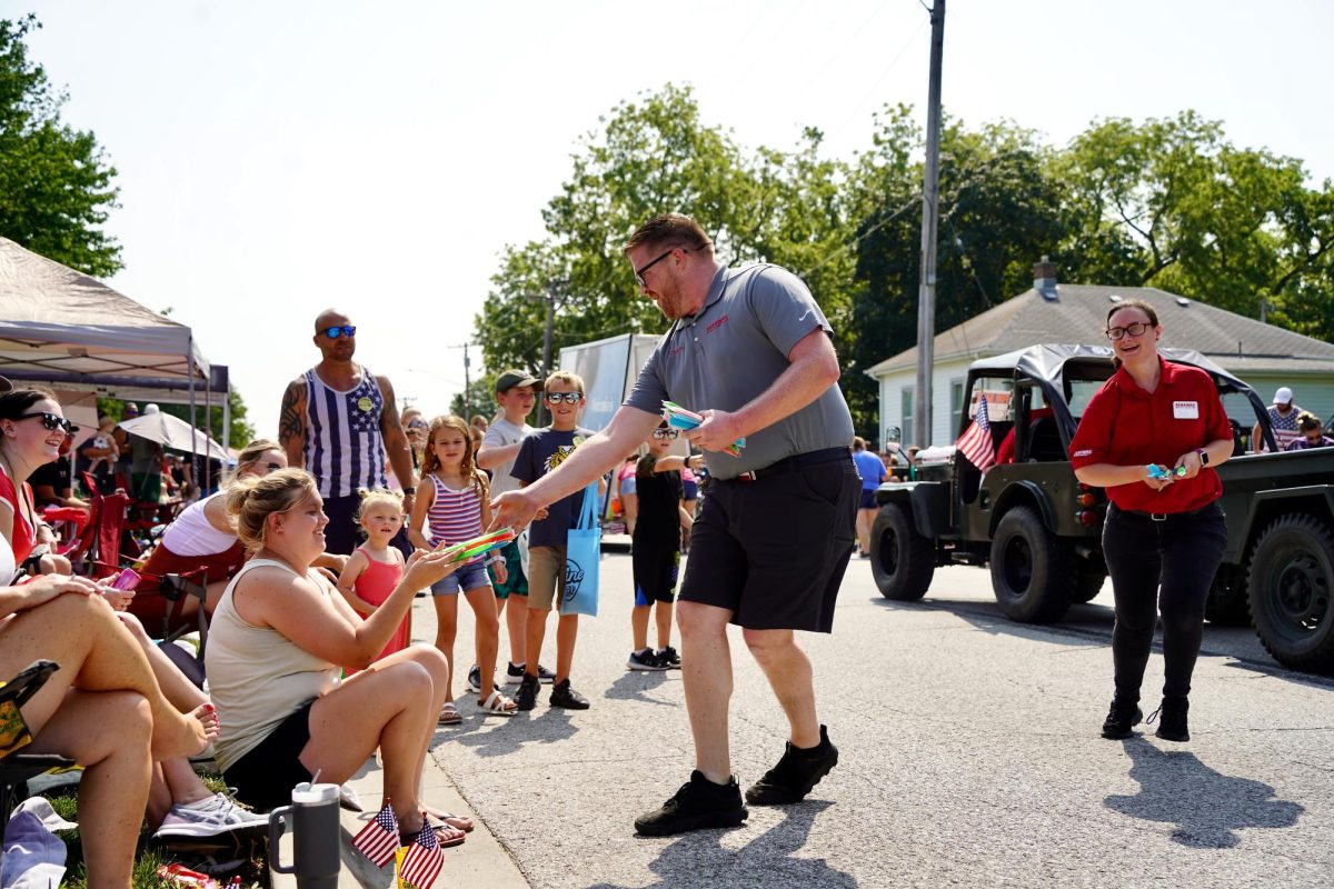 Passing out a unique treat, Fareway employees give popsicles to the crowd instead of the usual candy. 