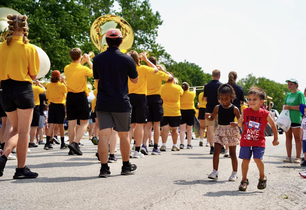 Dancing along to the sound of the GEHS marching band, two young children jump with smiles. 