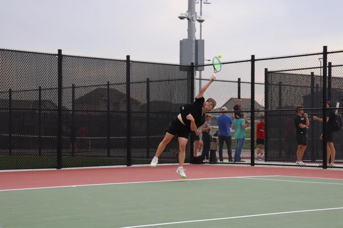 Twisting his body in the air, junior Ethan Boukal overhead smashes the ball towards his opponent. Boukal won this game 8-0.