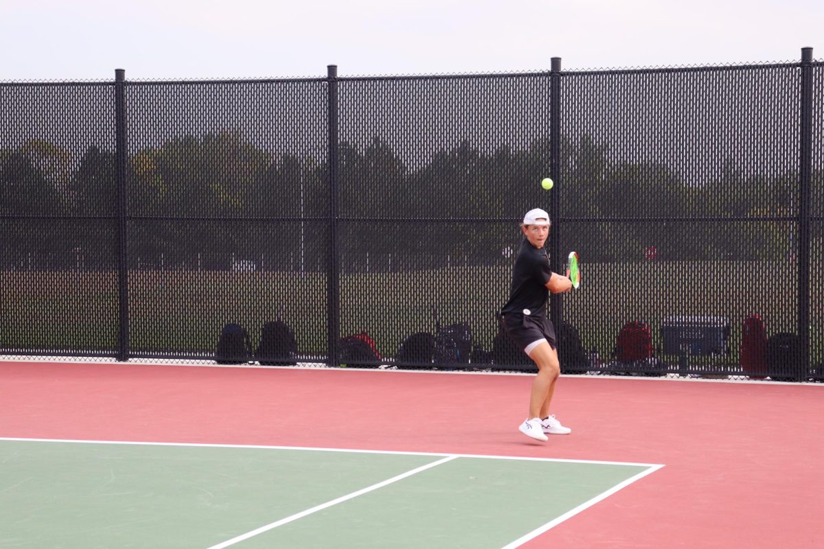 Preparing to use his go-to backhand, senior Tyler Gilliland sets his feet in preparation. Gilliland won this point by an error from his opponent.