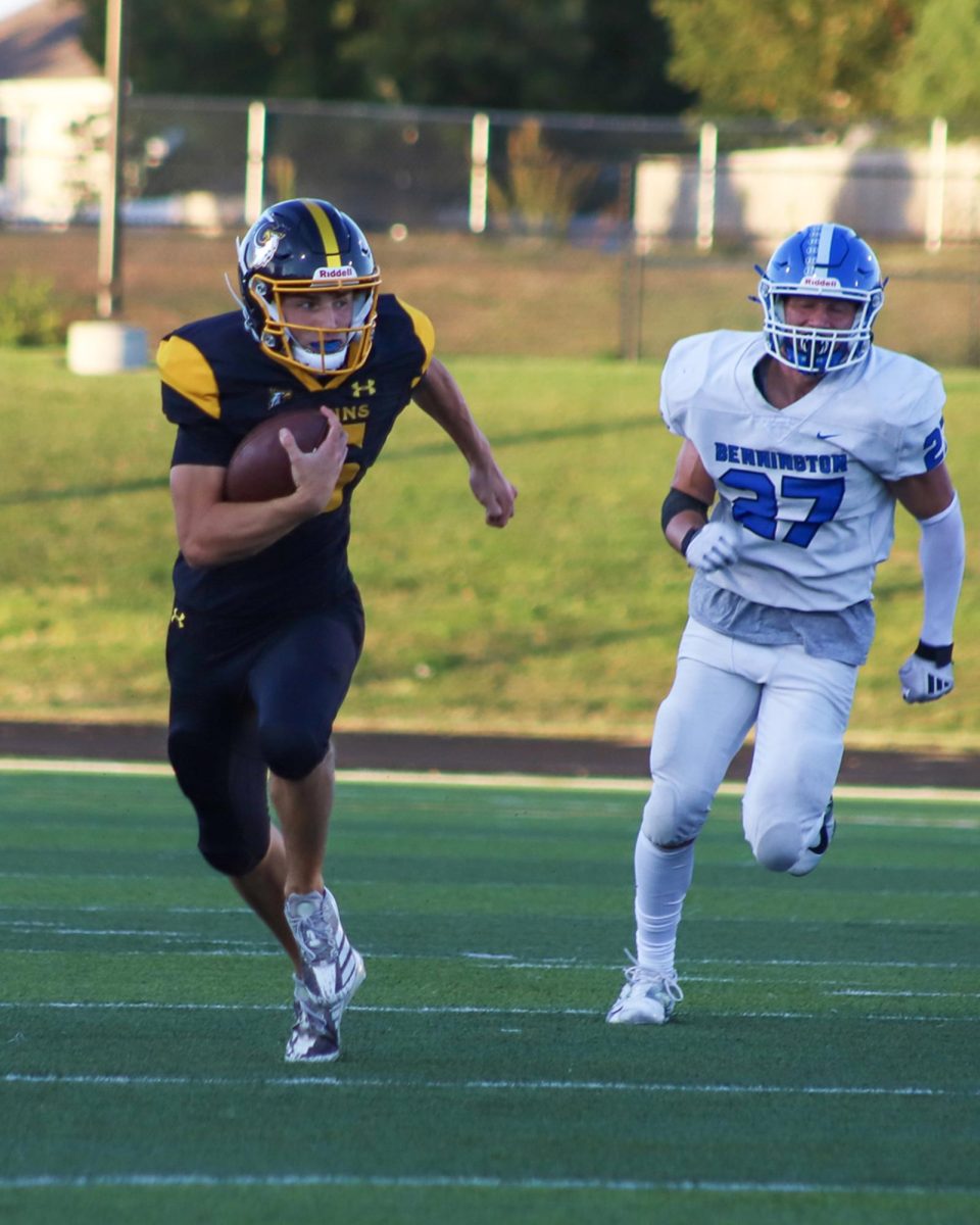 Quarterback Chase Grow (27) scrambles for a first down with a Bennington Badger in hot pursuit on Friday, September 6th