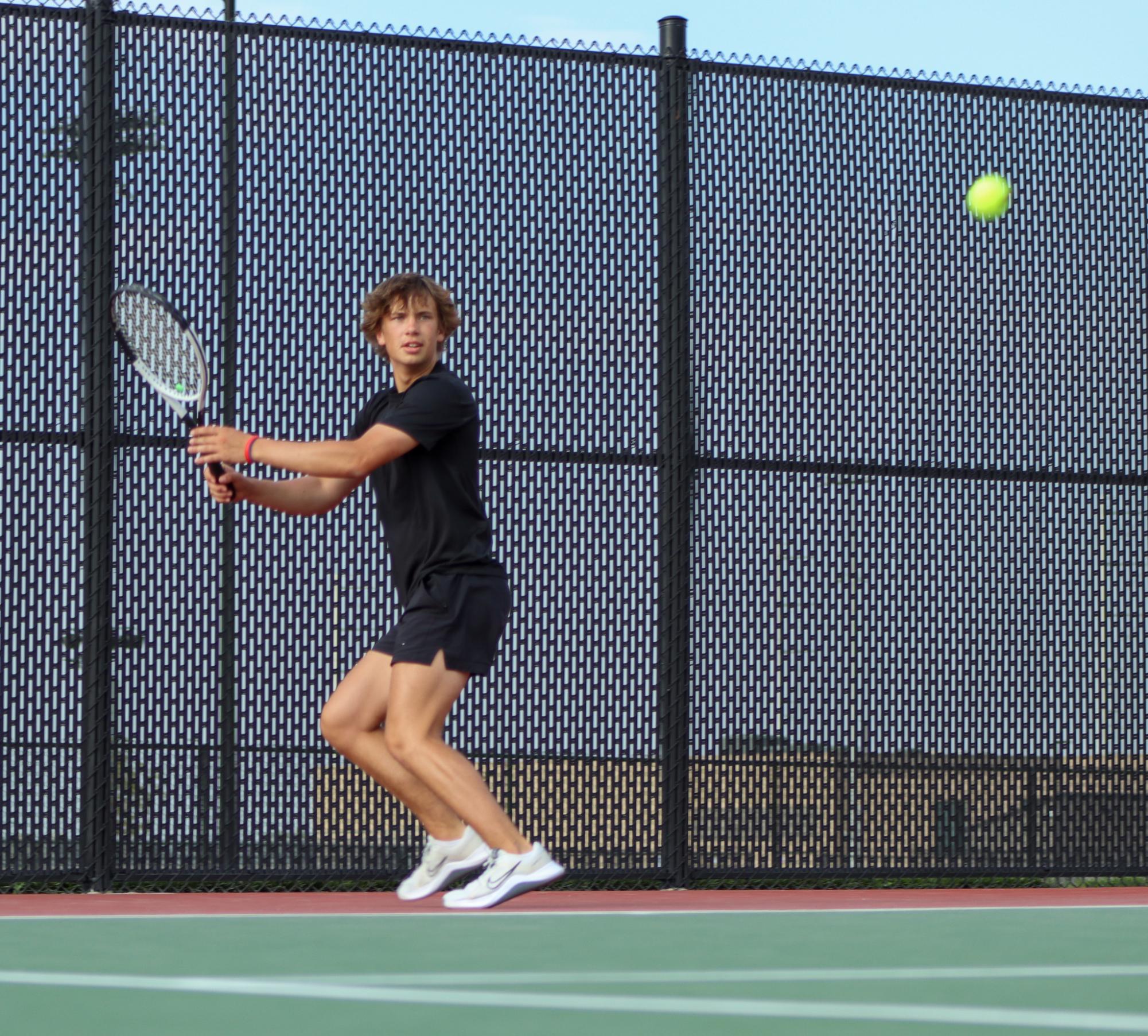 Setting his feet, senior Leo Feak prepares to return the serve back. Feak won his double's match 8-2 with junior Wyatt Estee.