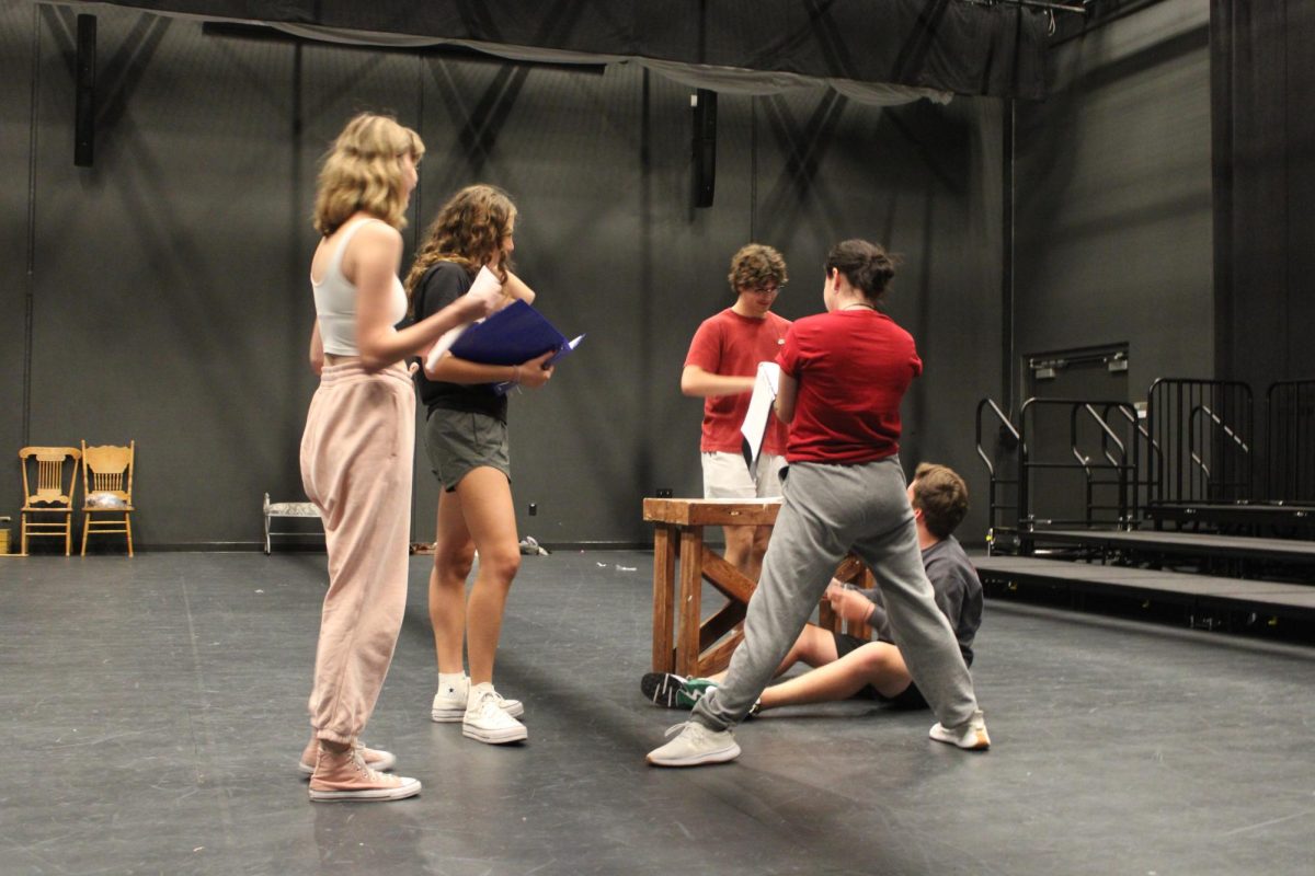 Rehearsing in the black box on Oct. 1, juniors Claire Hayworth and Joel Berck, along with seniors Andrew Jones and Elena Bunker discuss the blocking with director Nicole Schlautman.