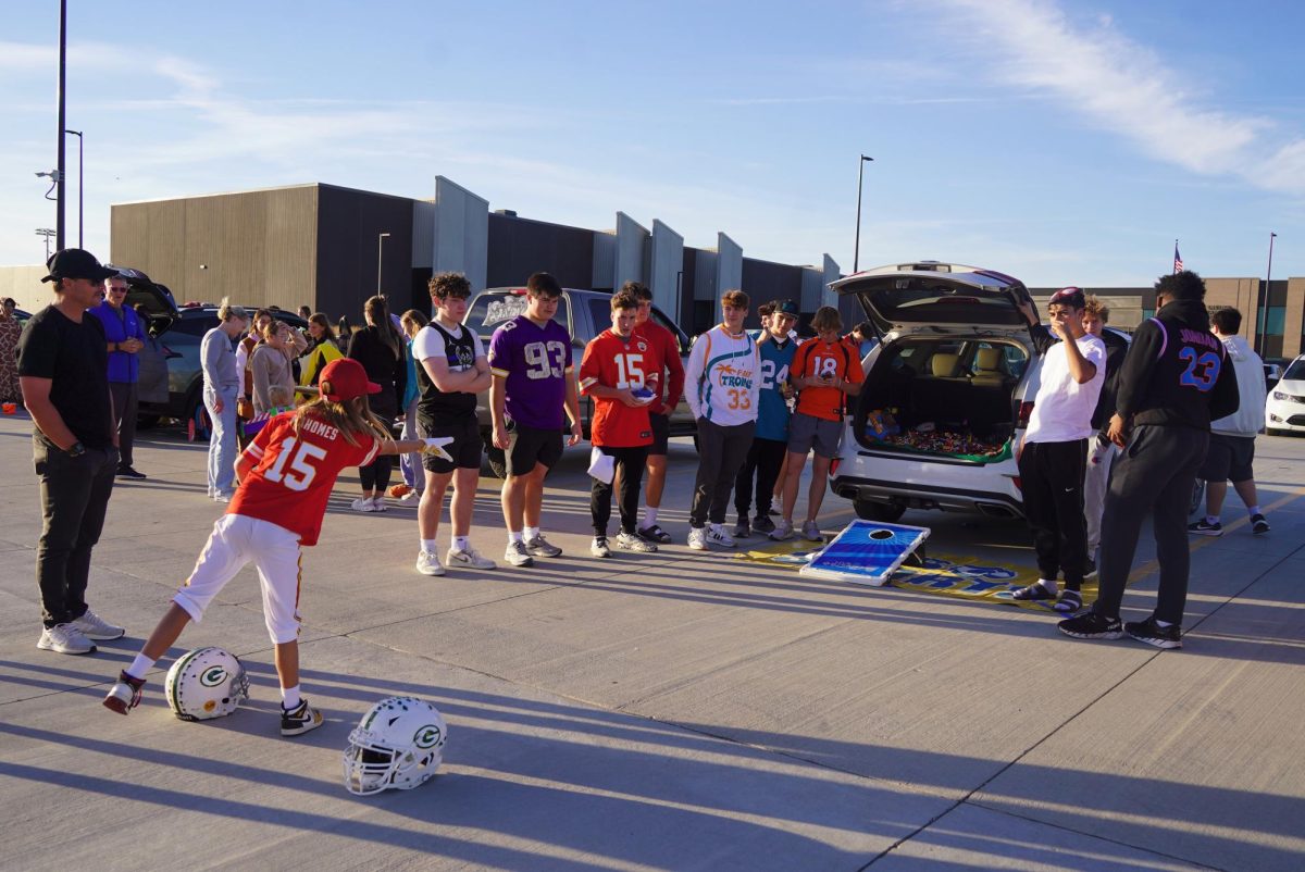 Playing cornhole, a Trunk-or-Treater plays the game of a sports themed trunk. 