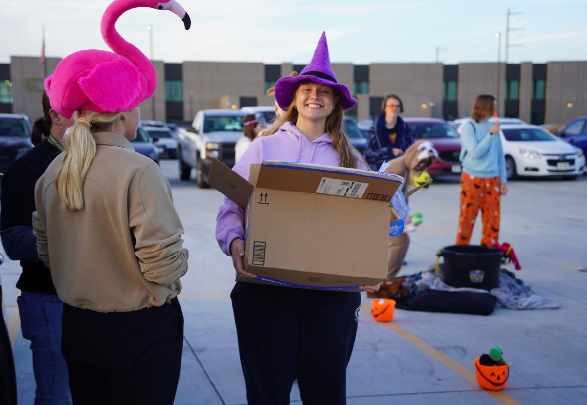 Smiling, senior Lily Matya holds a box of donations. As one of the NHS leaders, Matya was tasked with handing out candy to the NHS members and handling donations with sponsor Christina Modrell. 