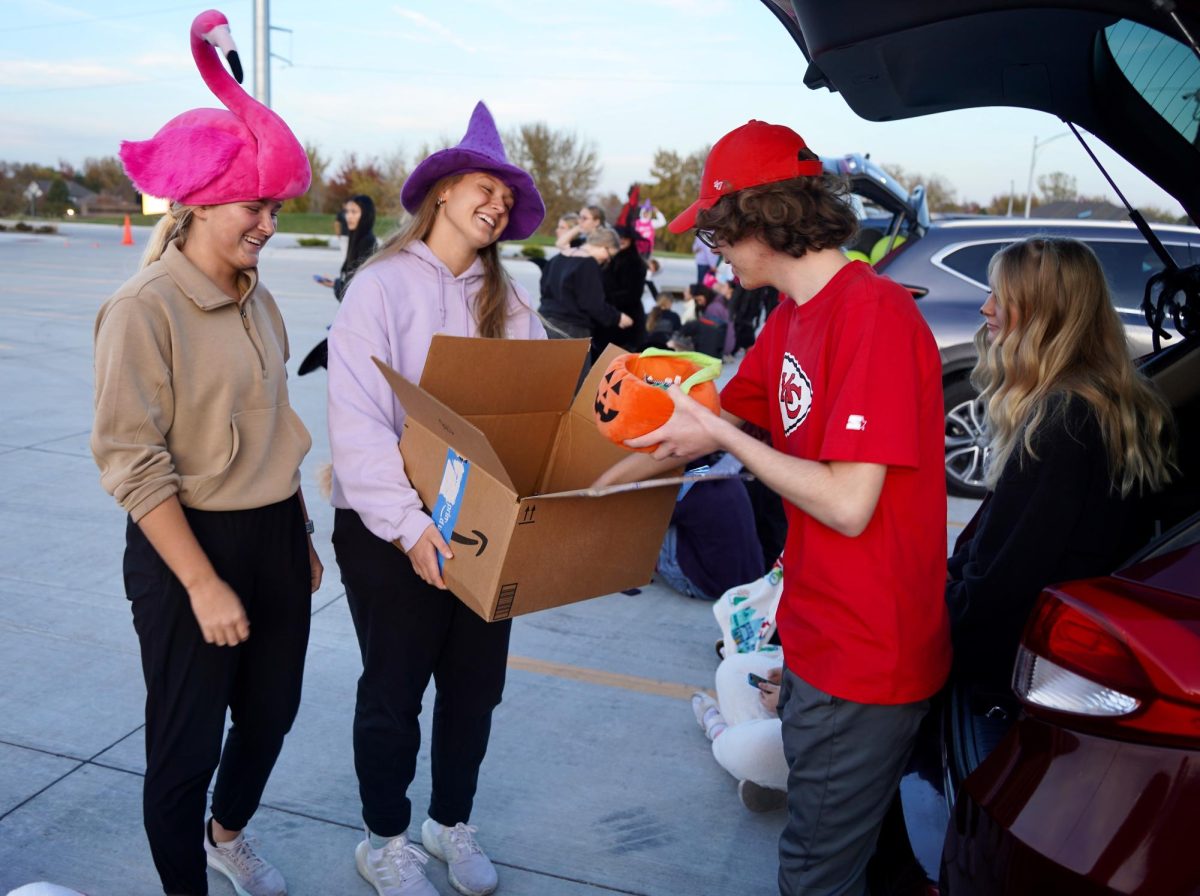 Getting a candy refill for his car, junior Brayden Hansen takes some from seniors Miranda Menousek and Lily Matya. 