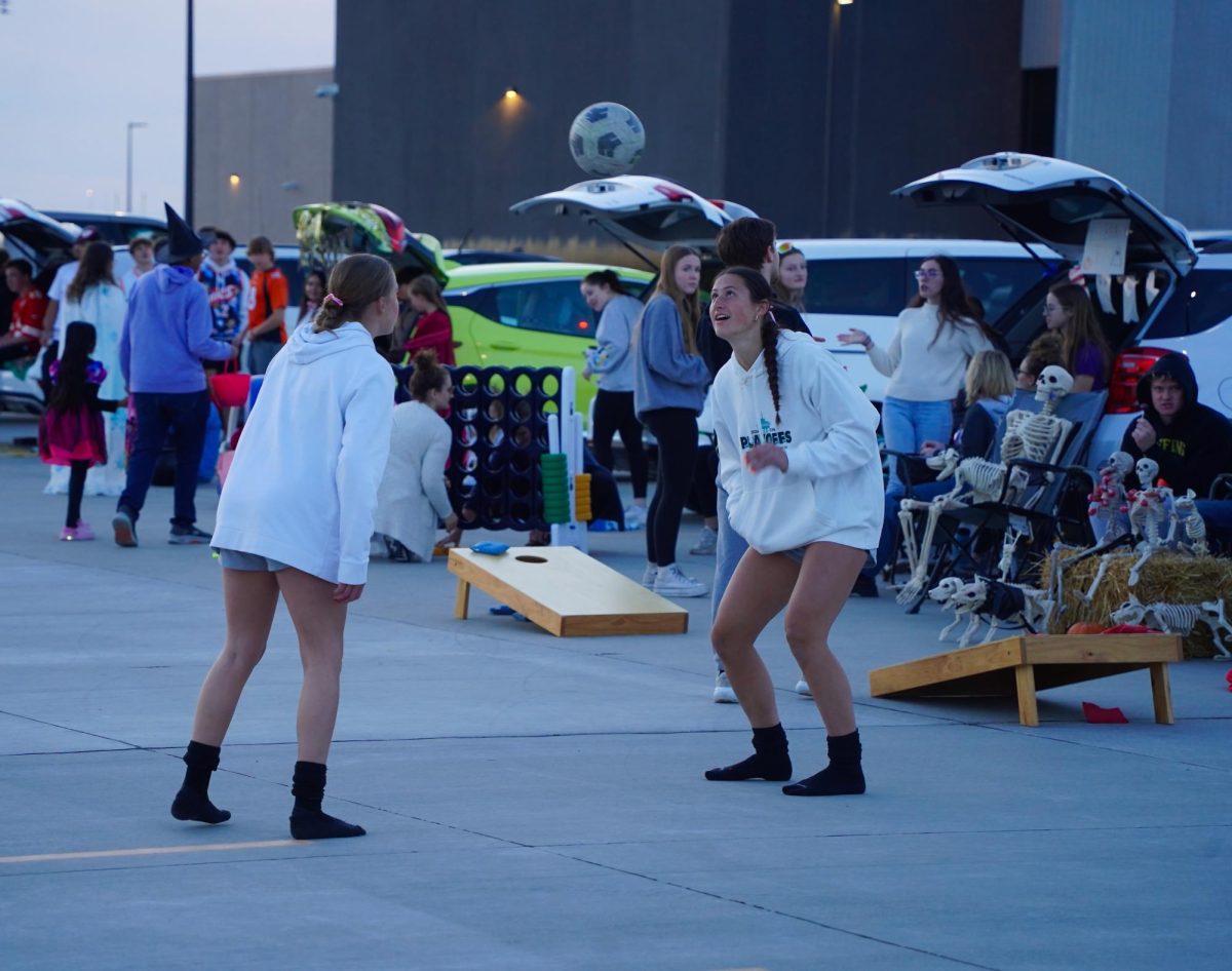 Bouncing the ball between each other, seniors Kendall Dobberstein and Sonora Defini practice their skills near the end of Trunk-or-Treat.