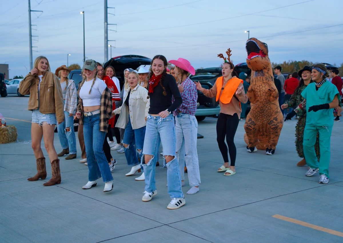 Dancing, a group of junior girls follow along to "The Cha Cha Slide." This trunk had a speaker and played Halloween songs throughout the event.