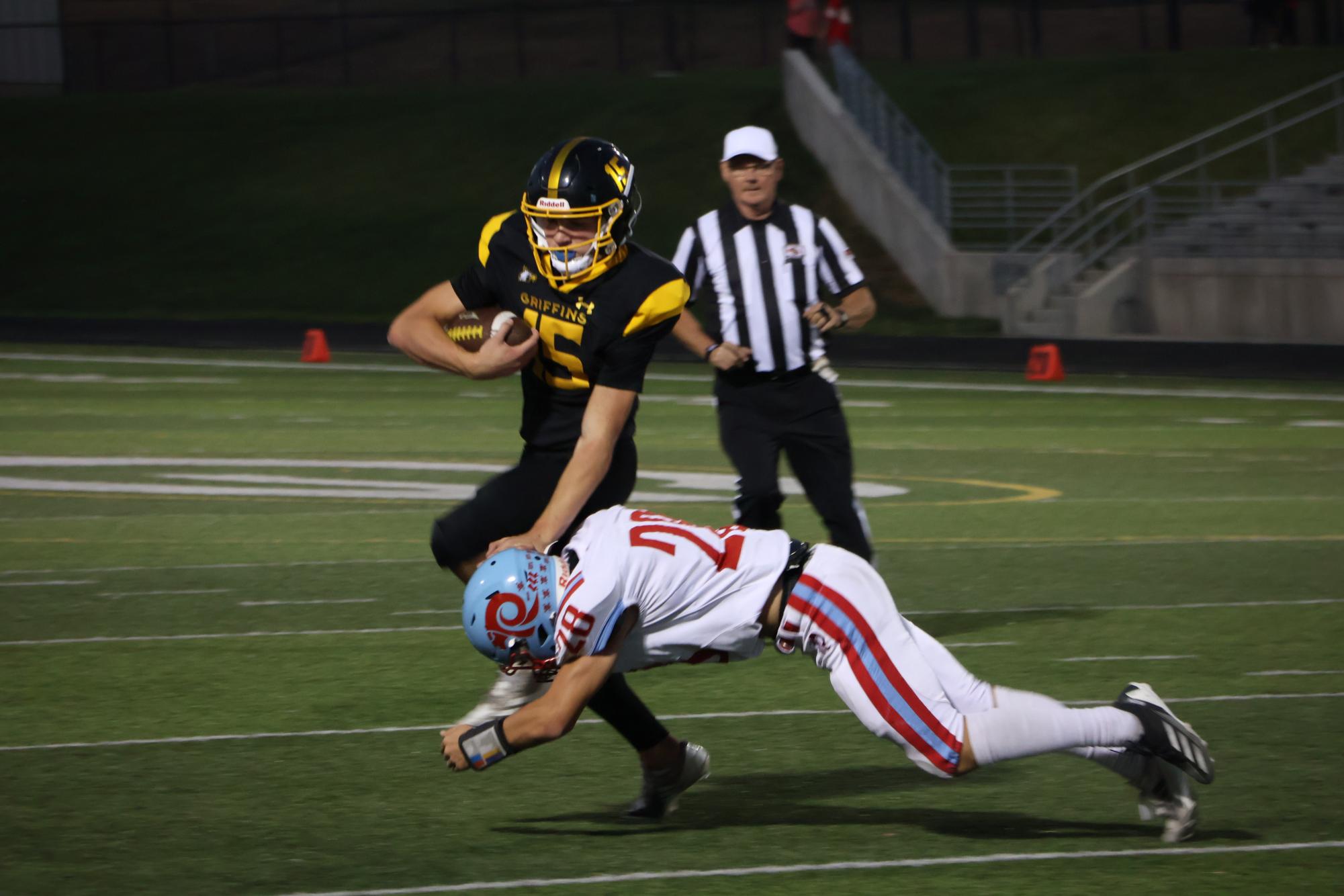 Stiff-arming the defender, sophomore Chase Grow fights for extra yardage on the Griffins first touchdown drive.