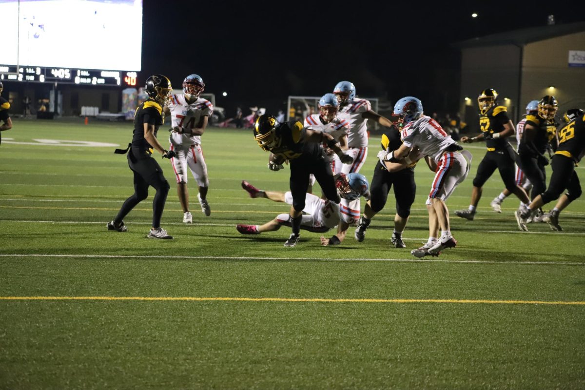 Breaking through the line, junior running back Connor Sams carries the ball for a Griffin touchdown.