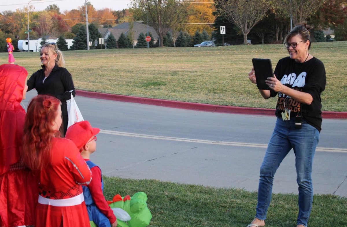 Asking a group of Trunk or Treaters to pose together, guidance counselor Amy Mullenberg snaps a picture of their costumes at the Palisades Trunk or Treat on Oct. 24. Mullenberg was seen documenting the entire event, from the costumes to the individual trunk designs.