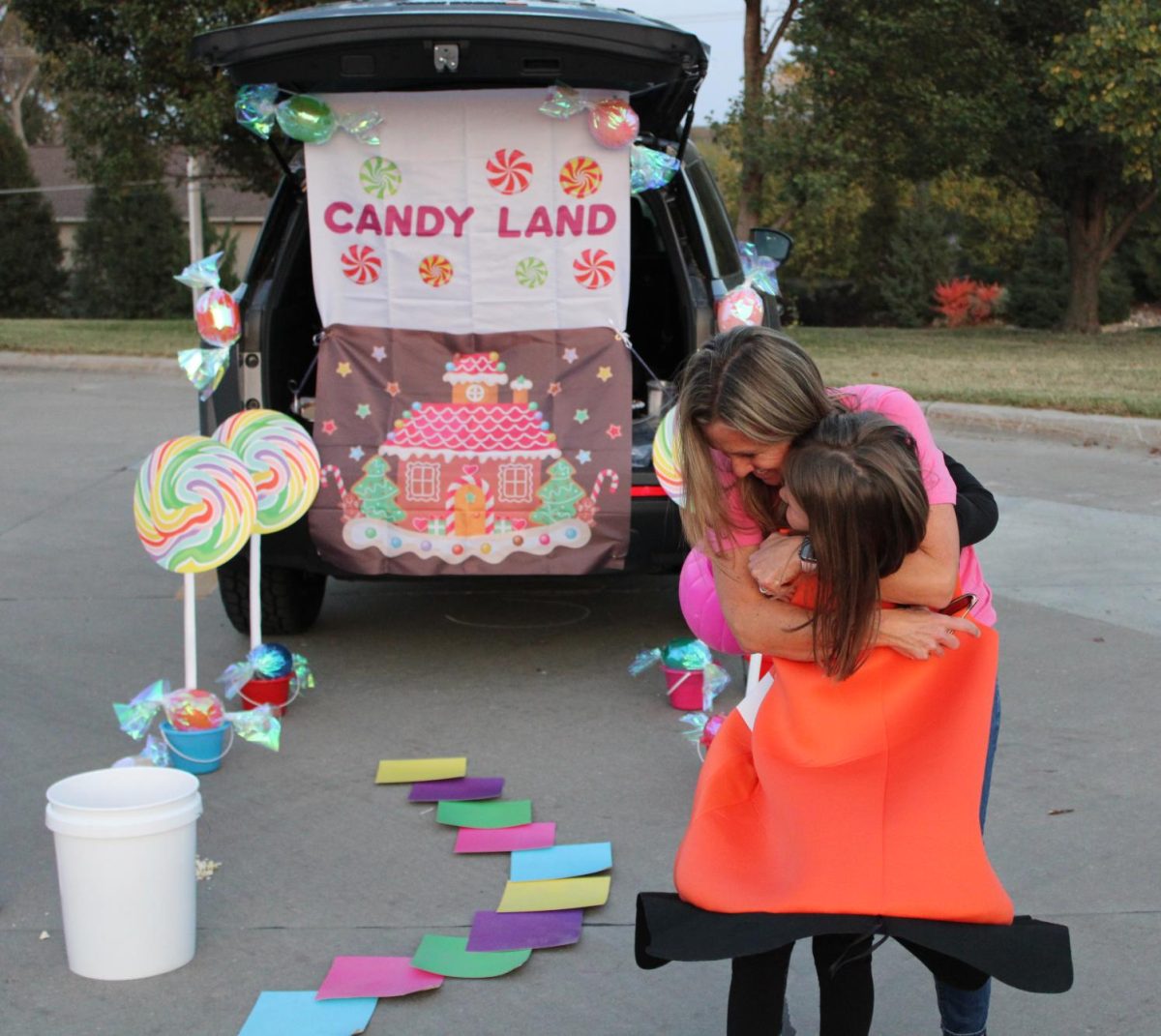 In front of her Candy Land themed trunk, kindergarten teacher Molly Harris pulls a former student into a hug on Oct. 24. Harris hadn't seen the student since last school year as the student transferred to Cedar Hollow.