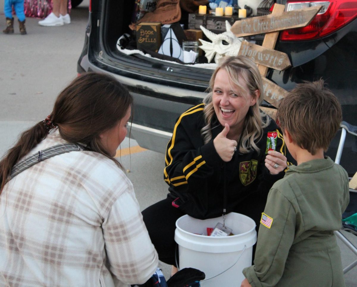 Interacting with the Trunk or Treaters, principal Karen Naylor asks a student to give her a thumbs up if he wants an Airhead. While the student was shy at first, he eventually gave in and gave a thumbs up.