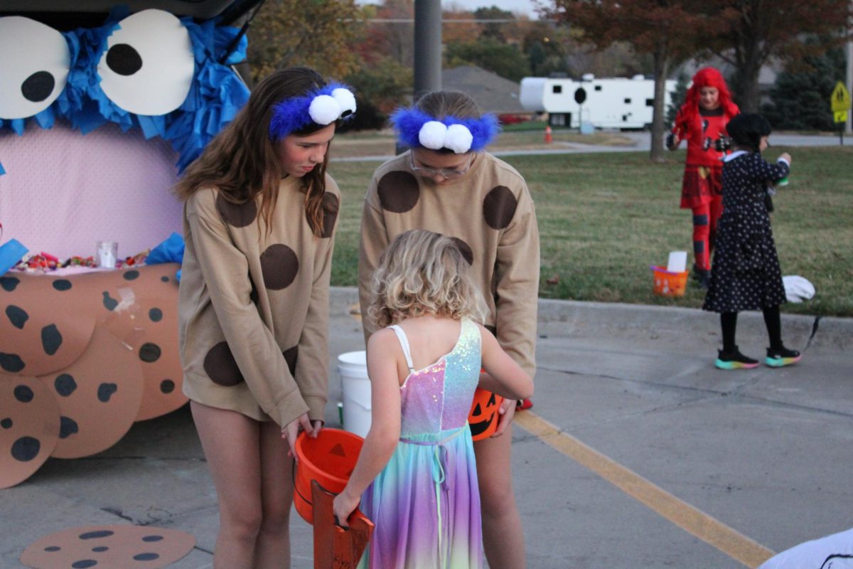 Dressed up as cookie monsters treats, two middle schoolers hand out not just candy but small prizes too. Cookie monster was a popular theme at the Palisades Trunk or Treat, with three seperate trunks decorated as the character.