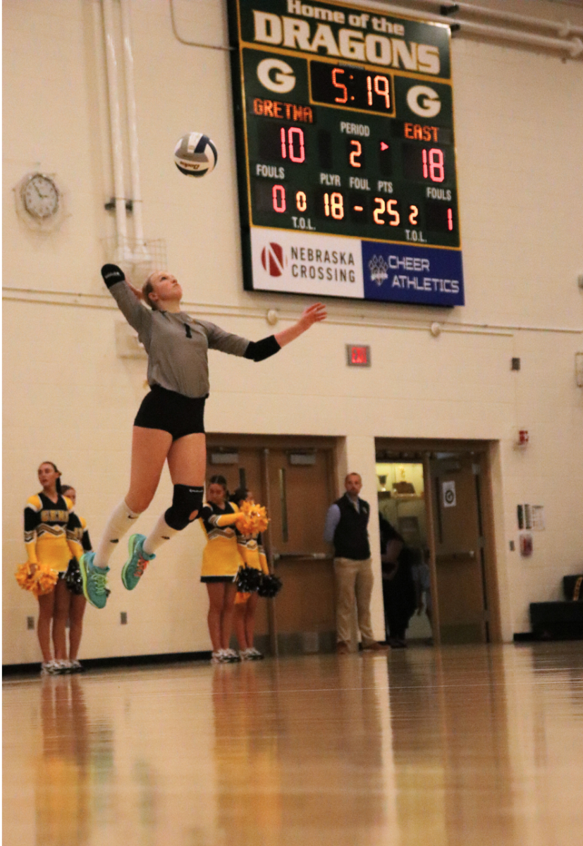 Jumping several feet in the air, libero, senior Maggie Williams serves to Gretna High during the second period of their game on Oct. 15. The Griffins went on to win the match 3-1 and then two days later defeated Elkhorn high 3-0. 