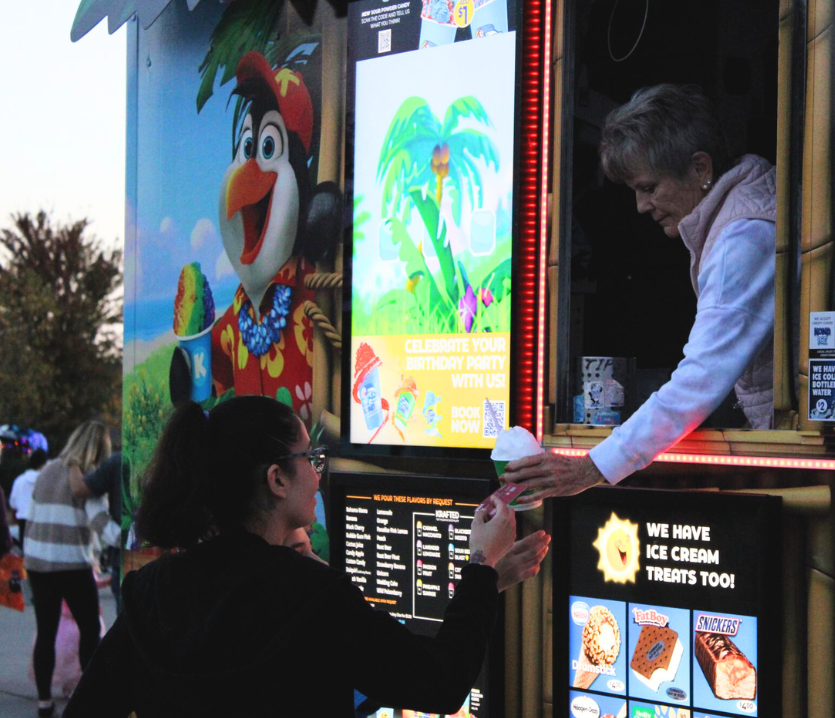 After visiting every trunk, a community member and her child purchase a treat from the Kona Ice truck at the Palisades Trunk or Treat. In addition to this, the Palisades event also had a photo booth for guests to use.