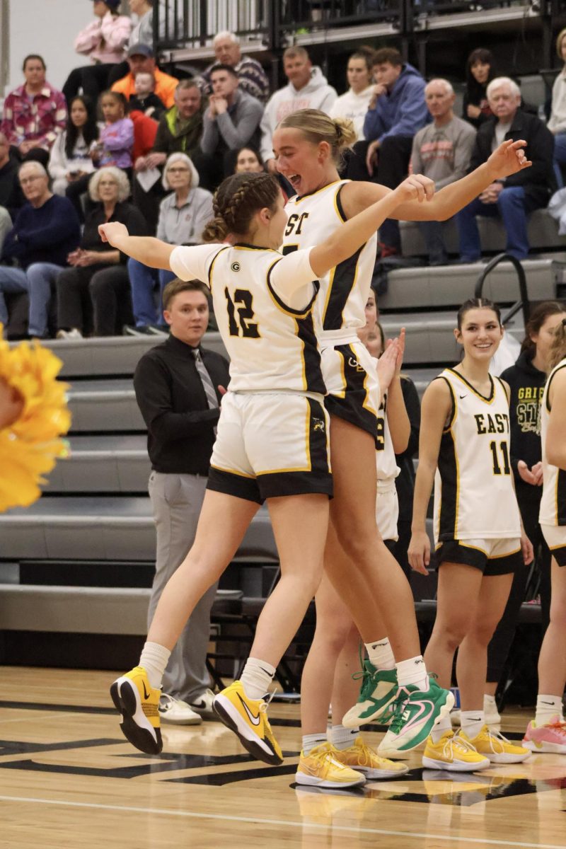 Bumping chests with each other, sophomore Sophia Lindsey and senior Hailey Levinson go through the starting lineups. 