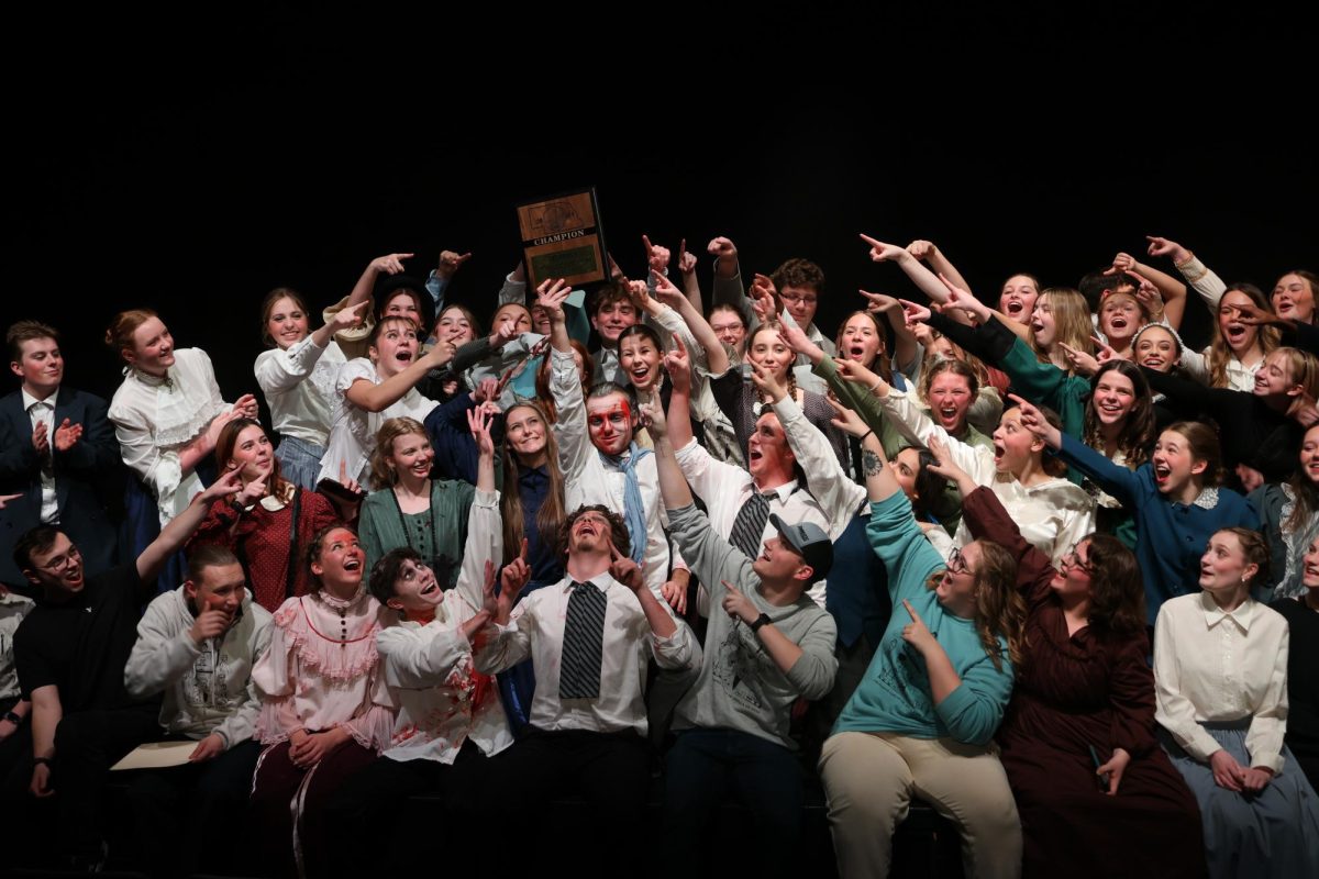 Smiling brightly, senior Cameron Anderson holds up the Nebraska School Activities Association (NSAA) A-2 district competition first place award. The team will be performing at the State Championship on Dec. 13.