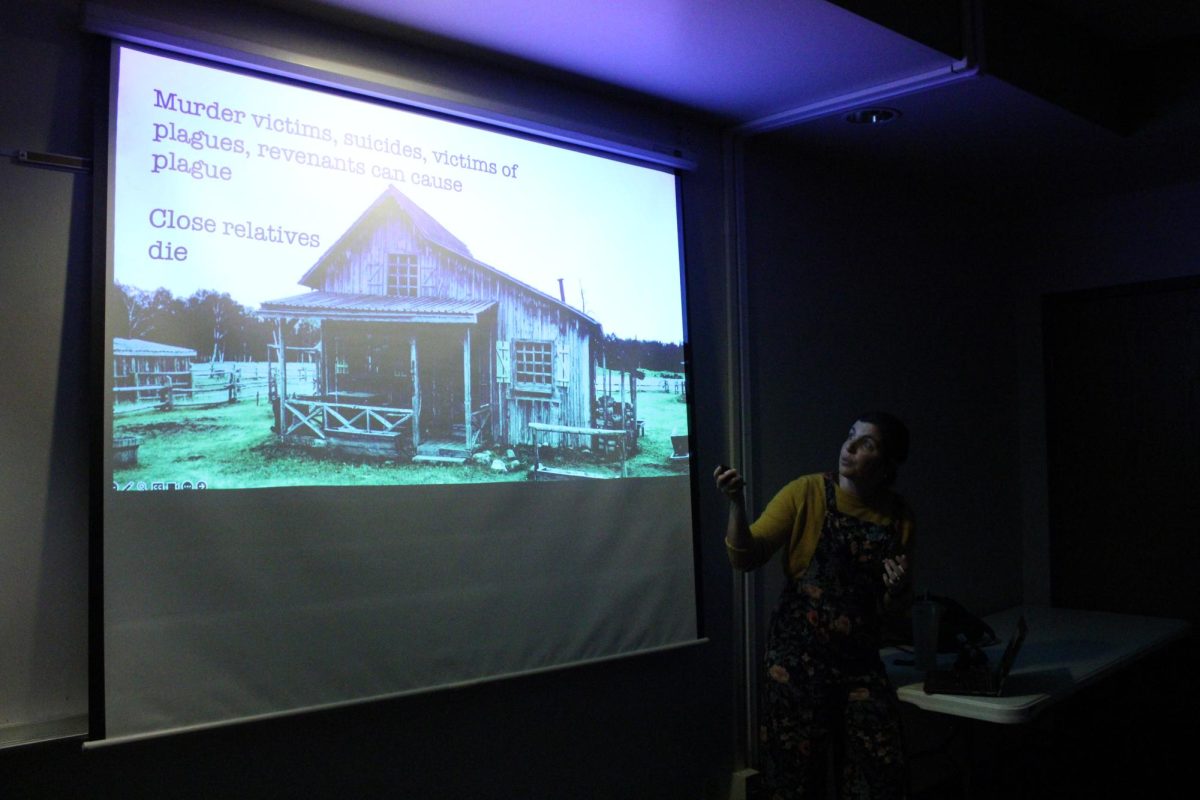 Explaining the history of vampires, PhD Forensic Anthropologist Katie East gestures to her presentation on Nov. 14.