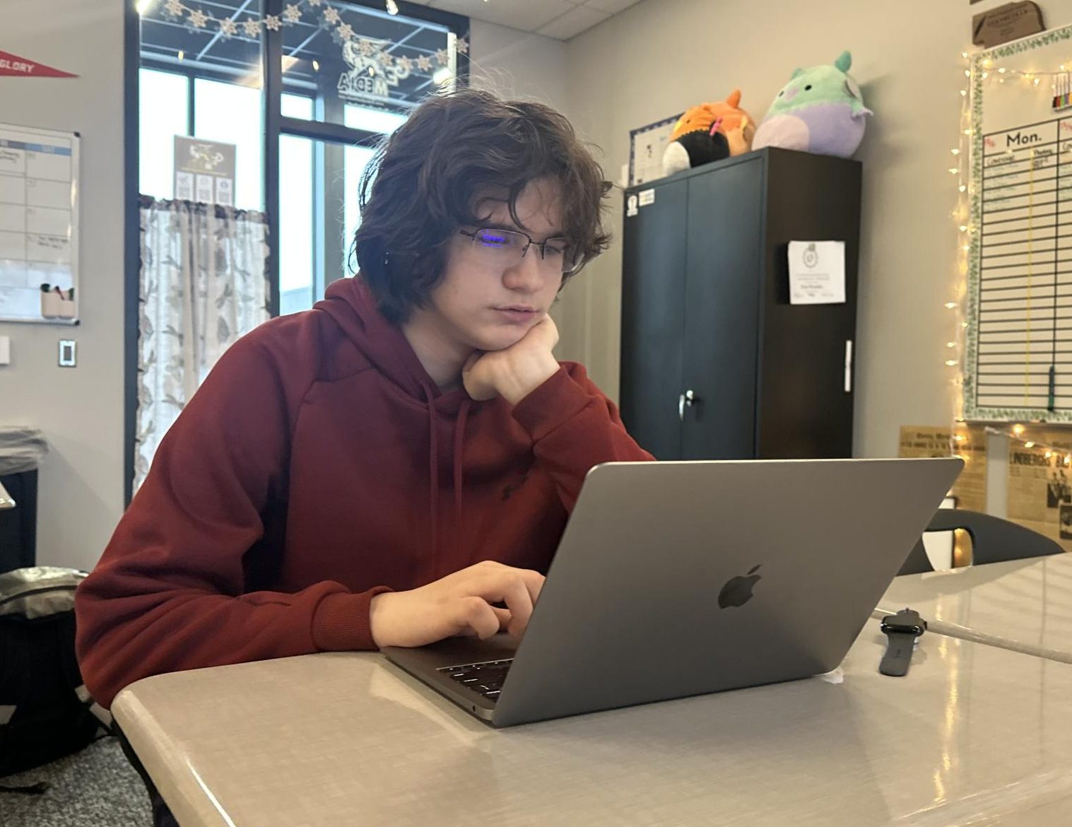 Sitting in his first hour class, sophomore Nicholas Mitchell works on assignments for yearbook class. 