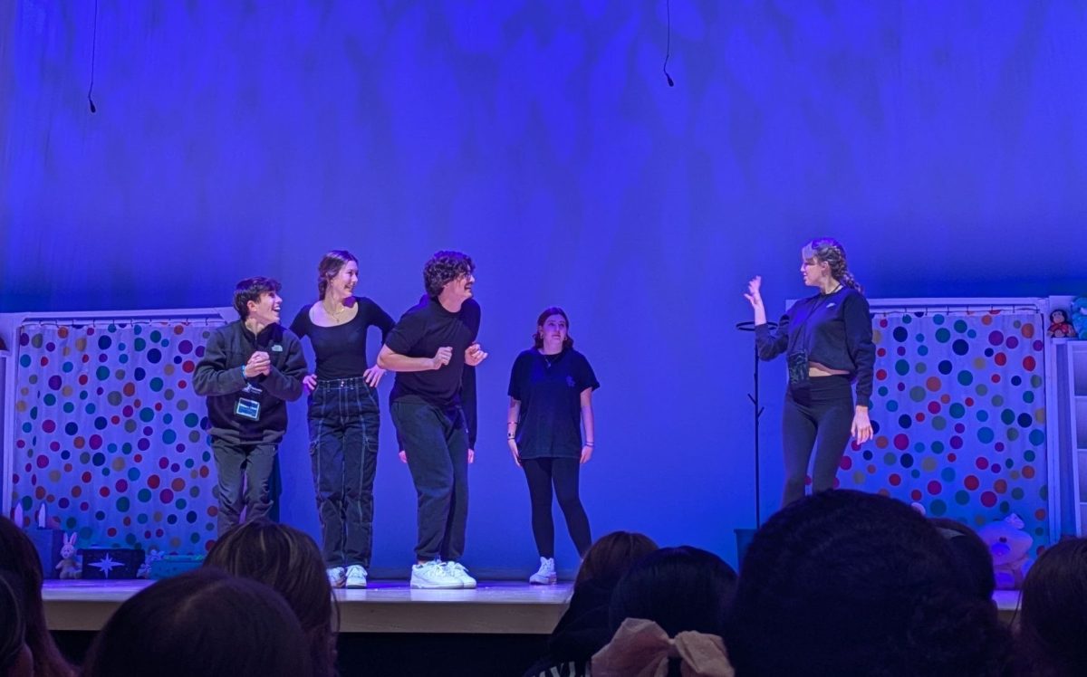 Jumping into the scene, junior Claire Hayworth waves to her improv teammates seniors Colton Knott, Andrew Jones and junior Jada Randecker as junior Olivia Weatherford and junior Adelaide Horst wait for the right moment to join the scene in the back.