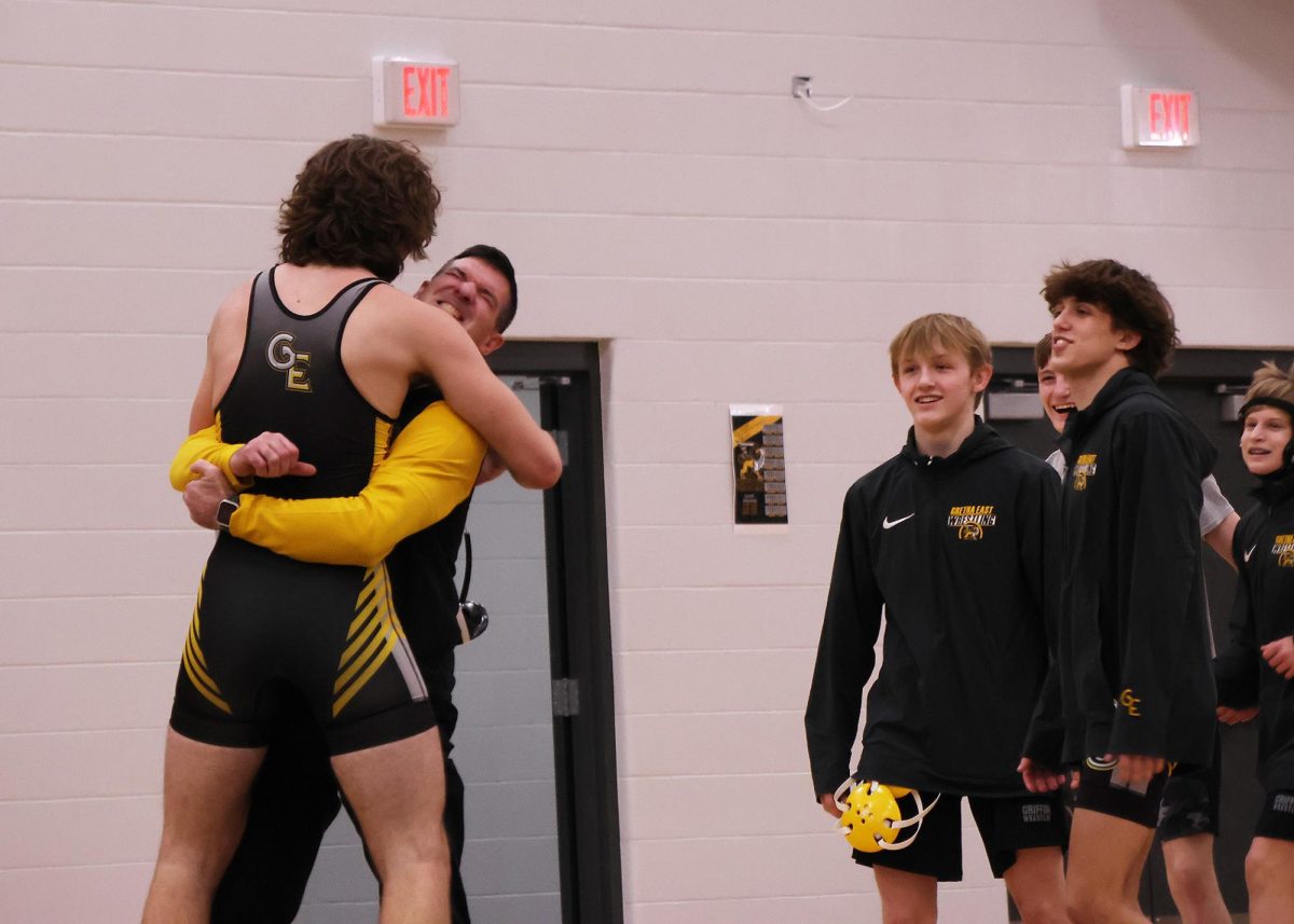 Proud of his wrestler, Head Coach Sean Cunningham wraps junior Evan Johnston in a bear hug after he won his match 6-0 on Feb. 6.