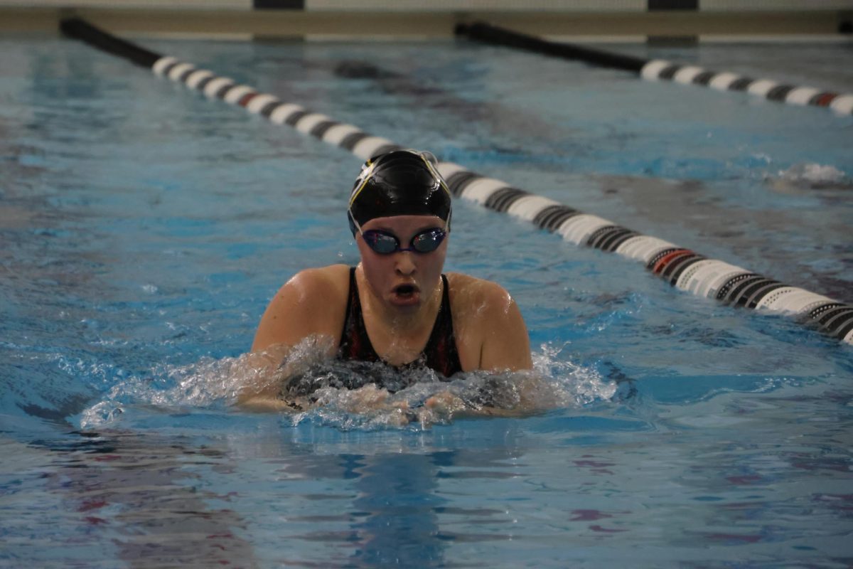 Swimming the 100 Yard Breaststroke at the Elkhorn Fete Fling Invitational on Feb. 2, senior Allyson Sherman pushes through the water. 