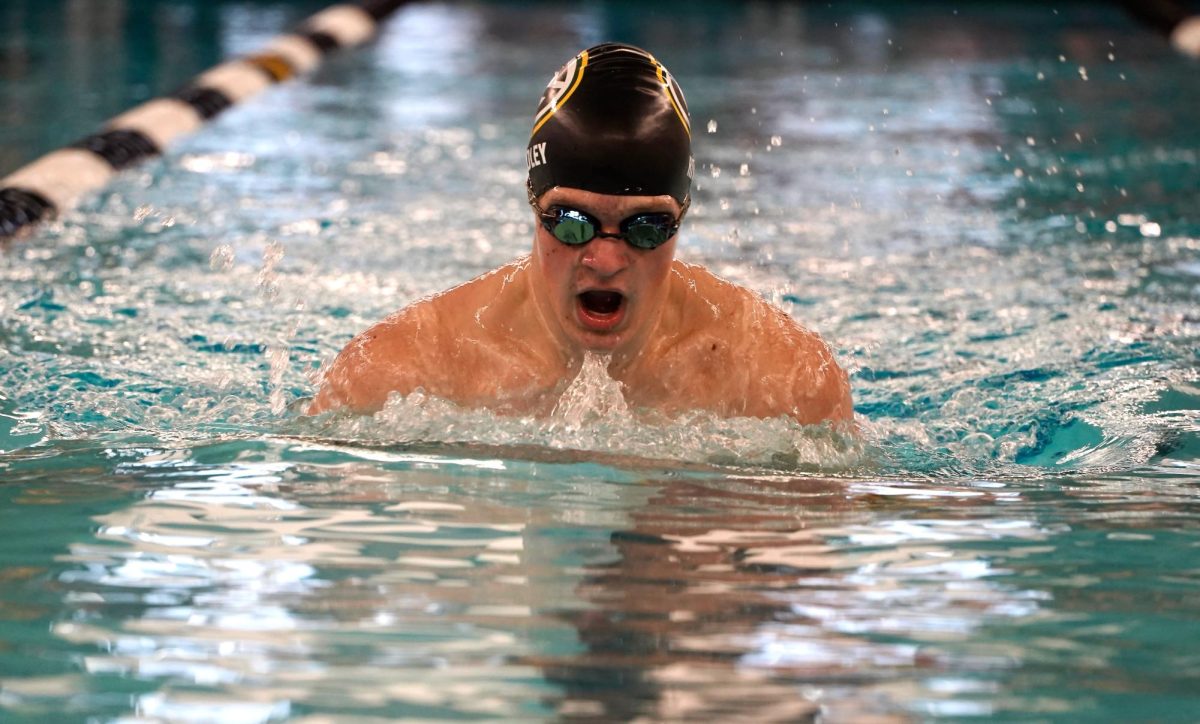 Looking down, junior Gunnar Ridley swims the 100 Yard Breaststroke. 