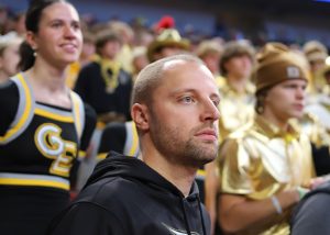 Watching the game, Athletic Director Ryan Garder stands in front of the student section at the Class B State Volleyball Semifinals on Nov. 11, 2023.