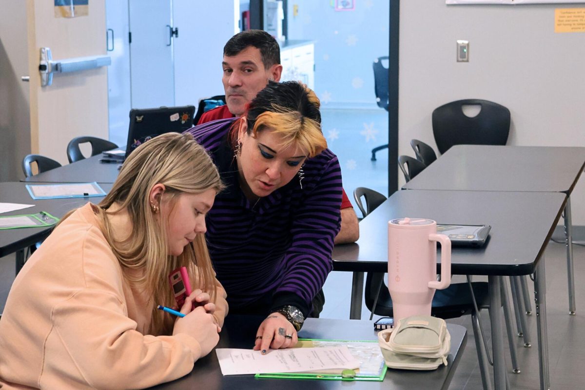 Because she knew she would be absent the next day, sophomore Alexis Gilliam meets with science teacher Jess Self during Centers on March 13, to take a chemistry test over stoichiometry that she would miss. 